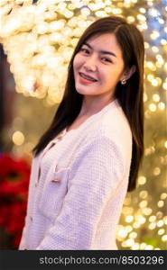 smile happiness portrait beautiful young asian woman wearing warm clothes Decoration During Christmas x-mas and New Year holidays at light circular bokeh background.