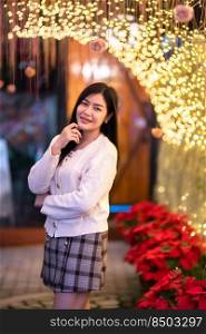 smile happiness portrait beautiful young asian woman wearing warm clothes Decoration During Christmas x-mas and New Year holidays at light circular bokeh background.