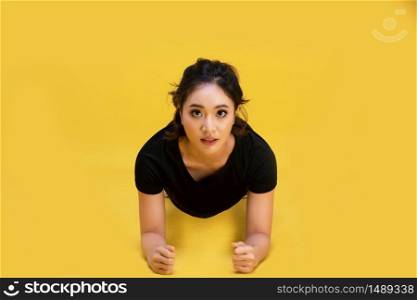 Smile happy Beautiful portrait young Asian woman stretching exercise workout on yellow background, fitness sport girl aerobic and healthy concept.