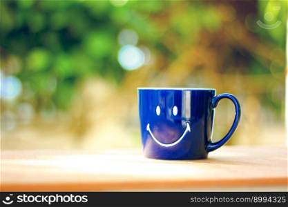 smile on blue mug coffee cup against blur bokeh abstract background
