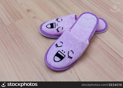 smile slippers and happy, close up view, on wooden floor