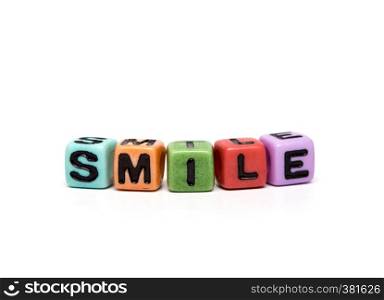 smile - word made from multicolored child toy cubes with letters