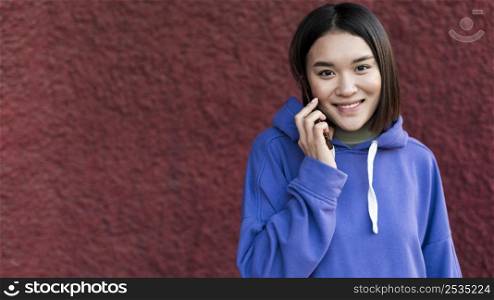 smiley asian woman talking phone