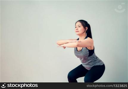 Smiley Asian woman wearing sportswear and practice yoga in living room. Healthy lifestyle concept.