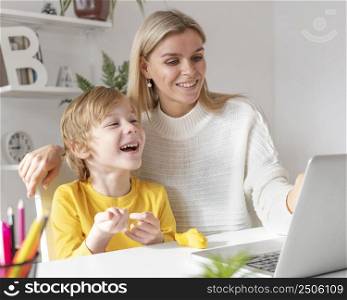 smiley boy mother using laptop home