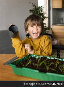 smiley boy with watering can crops home