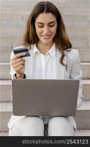 smiley businesswoman shopping online with laptop credit card