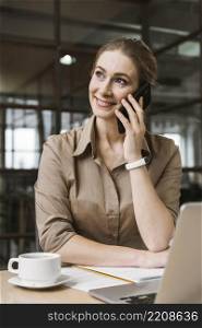 smiley businesswoman talking phone during meeting