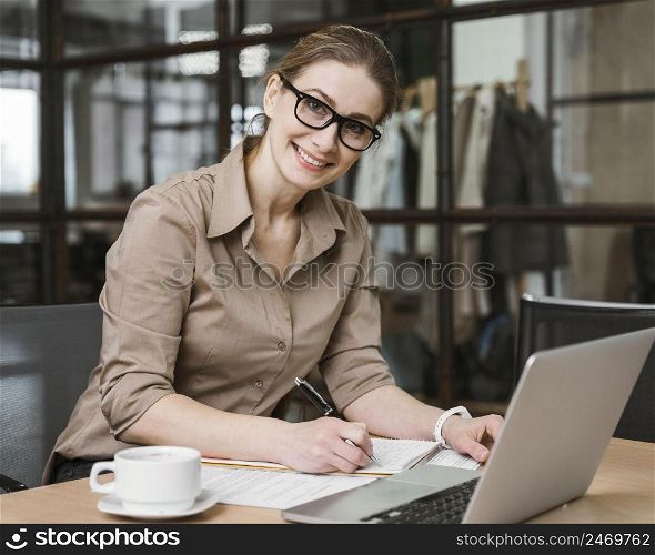 smiley businesswoman working with laptop desk