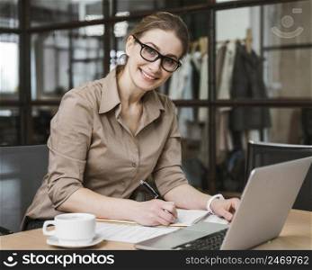 smiley businesswoman working with laptop desk