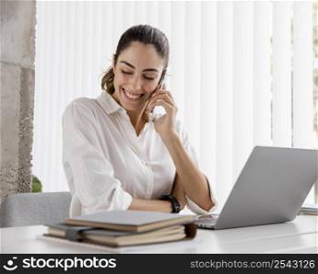 smiley businesswoman working with smartphone laptop