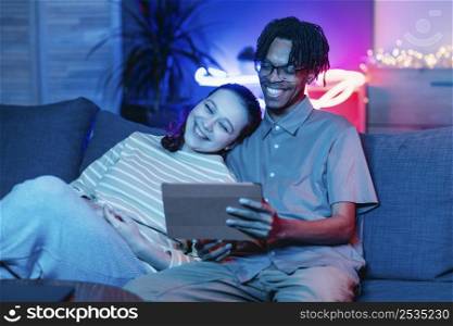 smiley couple couch using tablet