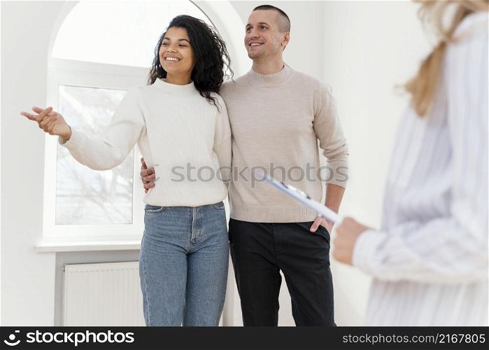 smiley couple seeing new house with realtor