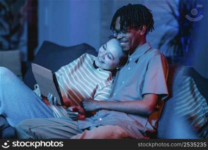 smiley couple sofa using tablet