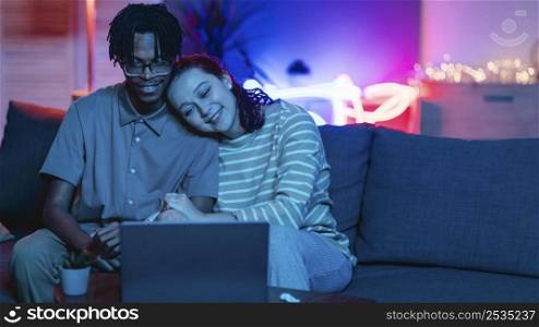 smiley couple using laptop home with copy space