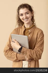 smiley curly haired lady holding laptop