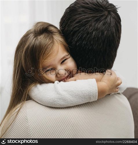 smiley daughter embracing her dad home
