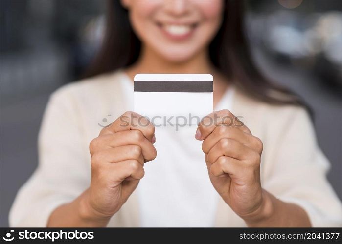 smiley defocused woman holding credit card