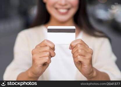 smiley defocused woman holding credit card