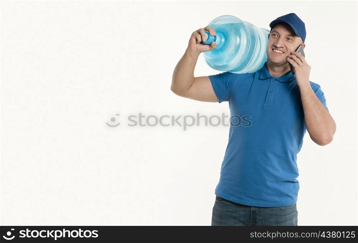 smiley delivery man holding smartphone carrying water bottle