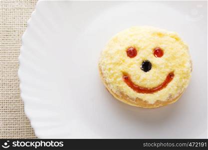 Smiley donut on a white plate, donut with white background