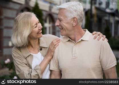 smiley elder couple taking walk city together