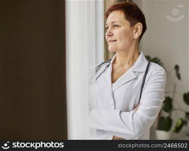 smiley elder covid recovery center female doctor looking through window