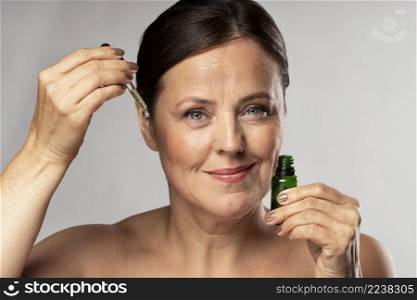 smiley elder woman using serum her face