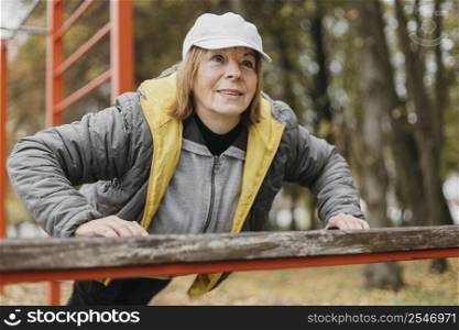 smiley elder woman working out outdoors