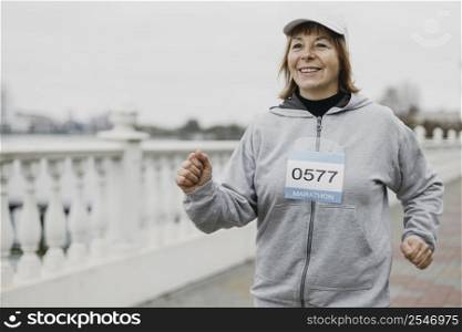 smiley elderly woman jogging outdoors with copy space