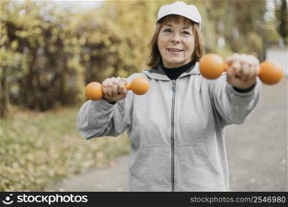 smiley elderly woman working out with weights