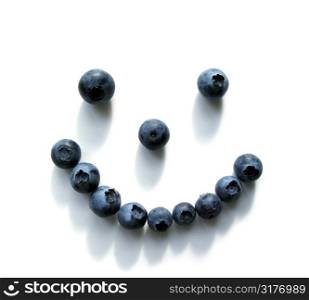 Smiley face made out of blueberries on white background...shadows add teeth:)