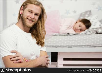 smiley father posing sleepy daughter home