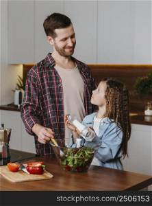 smiley father with daughter preparing food kitchen