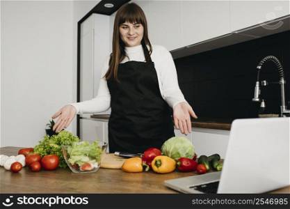 smiley female blogger streaming cooking with laptop home