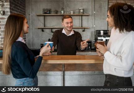 smiley female colleagues having coffee during meeting