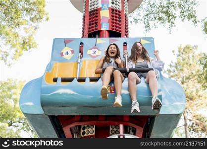 smiley female friends having fun amusement park