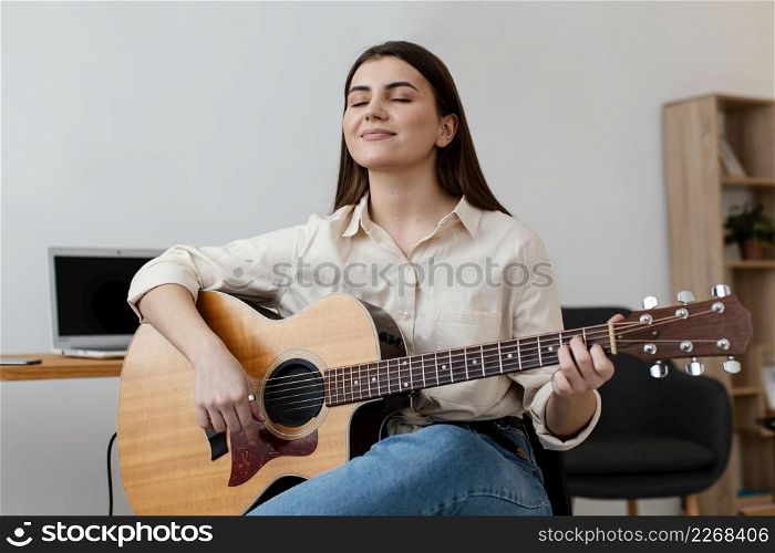 smiley female musician playing acoustic guitar
