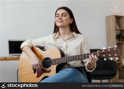 smiley female musician playing acoustic guitar
