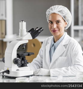 smiley female researcher biotechnology laboratory with microscope