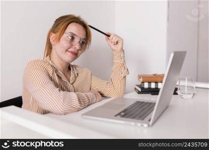 smiley female teacher using laptop during online class