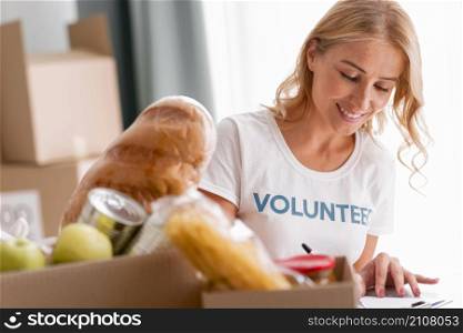 smiley female volunteer helping with food donations