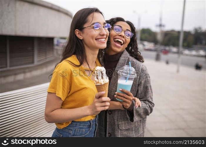 smiley friends having fun together outdoors with milkshakes