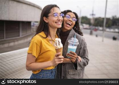 smiley friends having fun together outdoors with milkshakes