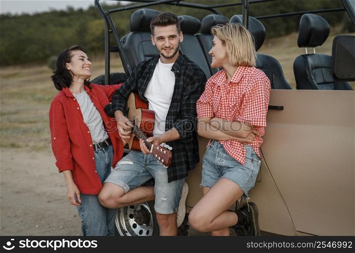 smiley friends playing guitar while traveling by car