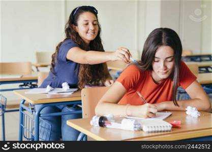 smiley girl distracting her schoolmate