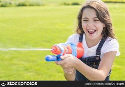 smiley girl playing with water gun