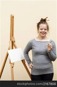 smiley girl with down syndrome posing with brush