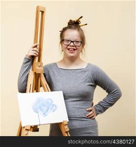 smiley girl with down syndrome posing with easel