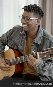 smiley male musician home playing guitar 2